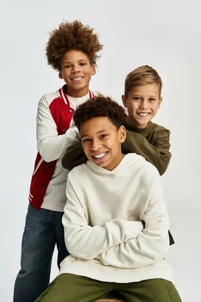 Tres adorables chicos disfrutan de la compañía de los demás, mostrando sus estilos de moda y alegría. - foto de stock