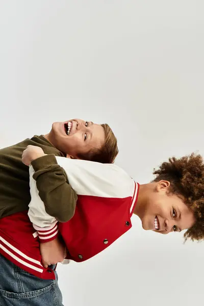 Dos chicos adorables comparten un momento alegre, mostrando sus trajes vibrantes y su fuerte vínculo. - foto de stock