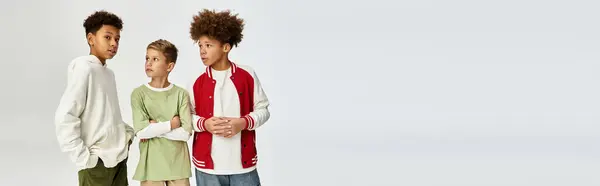 Three adorable little boys stand together in trendy outfits, radiating joy and camaraderie. — Stock Photo