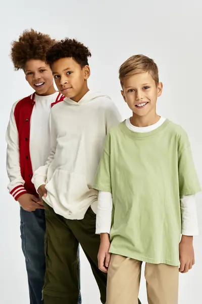 Tres adorables chicos exhiben su vibrante atuendo mientras comparten un momento alegre de amistad. - foto de stock