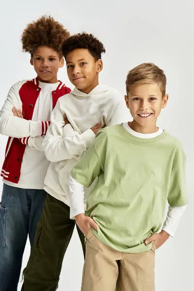 Three adorable boys dressed in bright outfits stand together, radiating joy and camaraderie. — Stock Photo