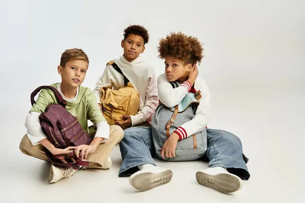 Trois garçons adorables mettent en valeur leur amitié alors qu'ils sont habillés en tenues colorées et à la mode. — Photo de stock