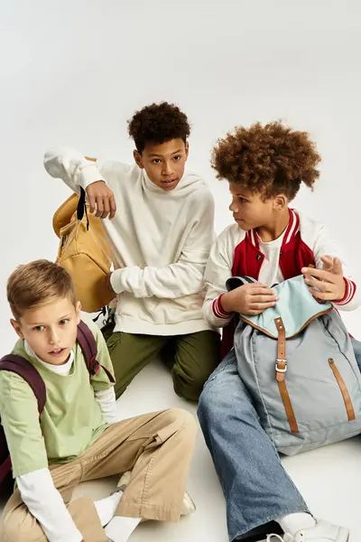 Tres chicos lindos comparten la risa y la amistad, vestidos con estilos vibrantes que muestran su estilo. - foto de stock