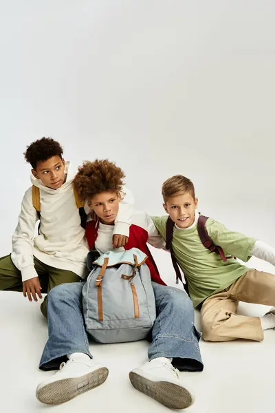 Three adorable boys dressed in fashionable attire enjoy each others company while posing together. — Stock Photo