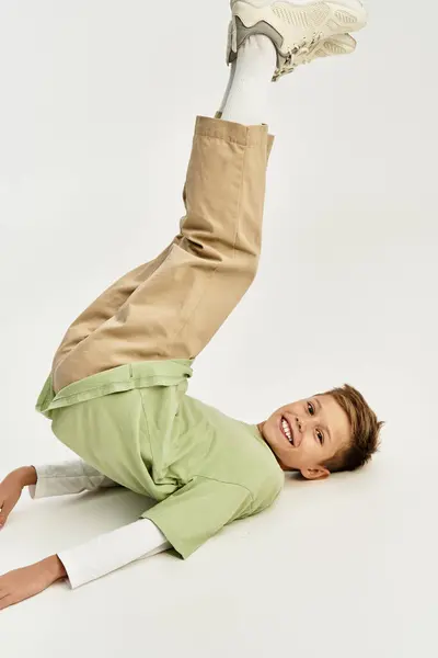 Adorable child dressed in stylish clothing brings joy with playful poses against a light background. — Stock Photo