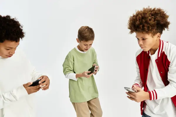 Adorables chicos están disfrutando de su tiempo juntos, comprometidos con los teléfonos mientras se visten con estilo. — Stock Photo