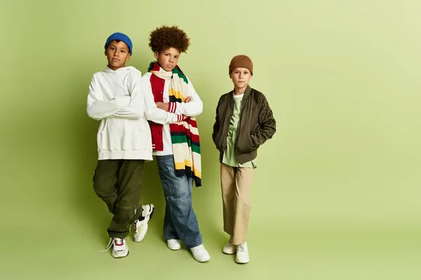 Tres niños pequeños muestran sus estilos únicos mientras retratan la esencia de la amistad y la alegría. - foto de stock