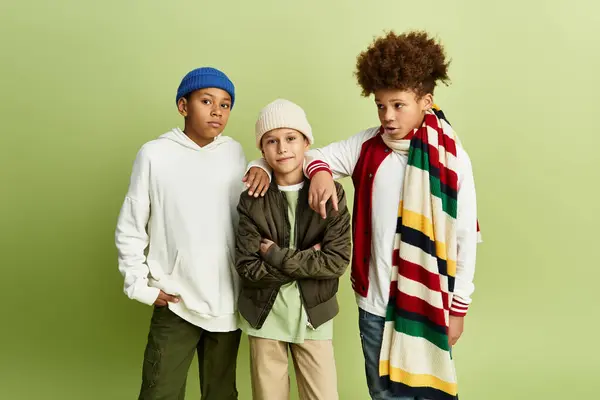 Tres adorables chicos vestidos con vibrante atuendo comparten un momento de alegría y amistad juntos. - foto de stock