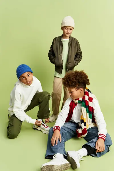 Three adorable boys showcase their vibrant fashion while sharing joyful moments indoors. — Stock Photo