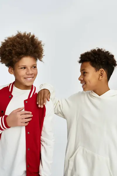 Dos niños vestidos con trajes elegantes comparten un momento alegre de amistad y conexión. - foto de stock