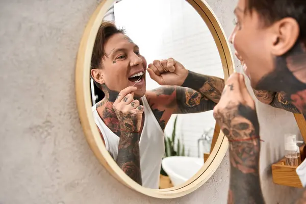 Junge tätowierte Mann in einem komfortablen Badezimmer Pflege, was Vertrauen und Selbstfürsorge. — Stockfoto