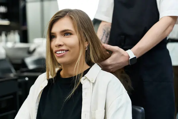 Client enjoys a hair treatment while professional stylist works with precision and care. — Stock Photo