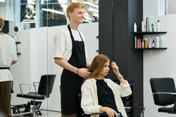 A stylist works on a clients hair while displaying the latest beauty trends in an elegant salon. — Stock Photo