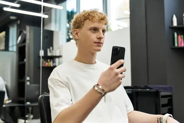Individual engages with a smartphone while seated in a modern beauty salon atmosphere. — Stock Photo