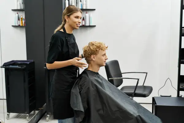 A stylist engages with a client while showcasing trendy haircut techniques and styles. — Stock Photo