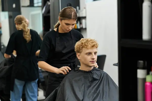 Estilista expertamente corta y estiliza el cabello para un cliente en un ambiente contemporáneo de salón de belleza. — Stock Photo