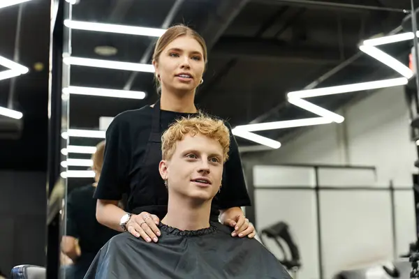 Stylish salon features a talented stylist prepping a client for a contemporary hair transformation. — Stock Photo