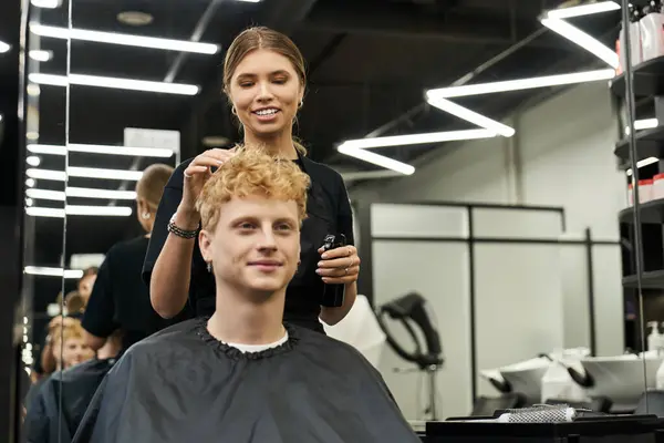 A skilled stylist works on a client, enhancing their look with trendy hairstyles in a vibrant salon. — Stock Photo