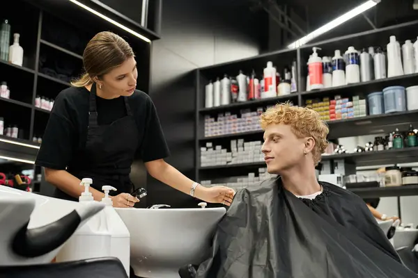 A skilled stylist engages with a client during a trendy haircut at a contemporary beauty salon. — Stock Photo