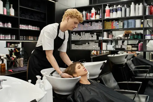 A stylist washes a clients hair among trendy beauty products in a chic salon. — Stock Photo