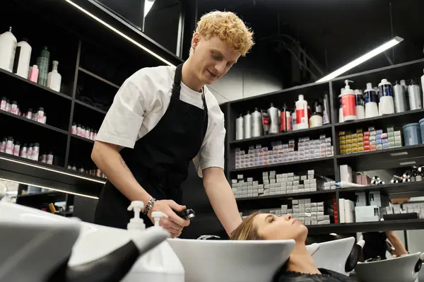 A skilled stylist applies treatment to a clients hair in a chic beauty salon filled with products. — Stock Photo