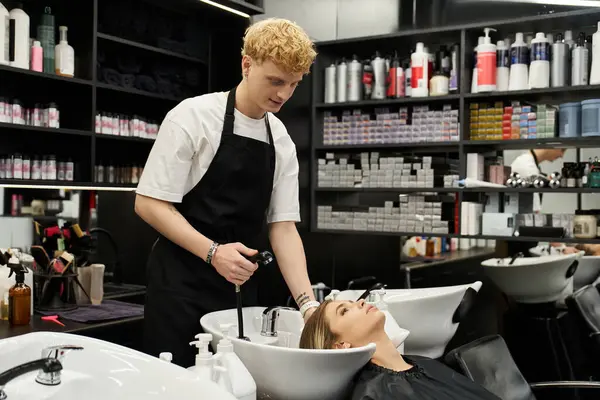 Un estilista lava expertamente el cabello de un cliente en un elegante salón de belleza, mostrando las tendencias actuales. — Stock Photo