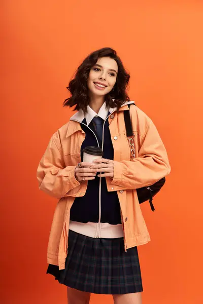 A young woman stands confidently in a chic outfit, brightening the studio with her vibrant presence. — Stock Photo