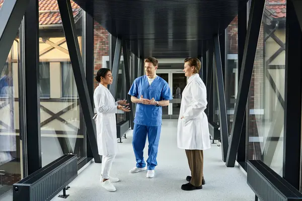 Three doctors engage in a lively discussion in a contemporary healthcare environment. — Stockfoto
