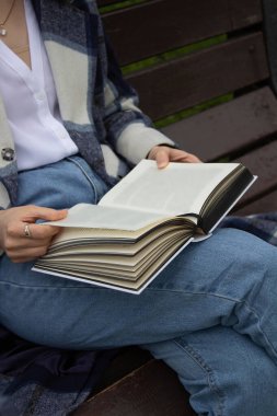 Dışarıda kitap okuyan bir kadın.