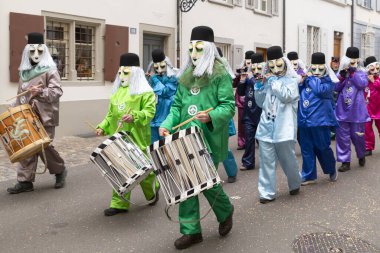 Basel, İsviçre - 1 Mart 2023. Bir grup karnaval katılımcısı davul çalıyor.