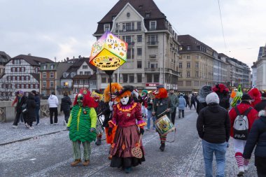 Basel, İsviçre - 28 Şubat 2023. Ortadaki köprüde kostümlü karnaval katılımcıları