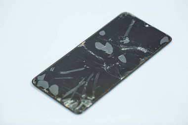 Gri arka planda kırılmış bir akıllı telefon ekranı. Yüzeyin derinliği.