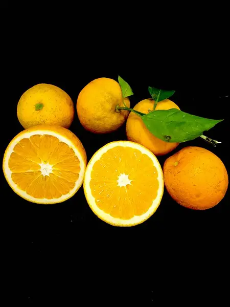 stock image Orange exposed cut in half, showing the beauty of the fruit inside, with several others whole