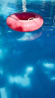 Uuma piscina azul com uma boia salva vidas cor de rosa na agua
