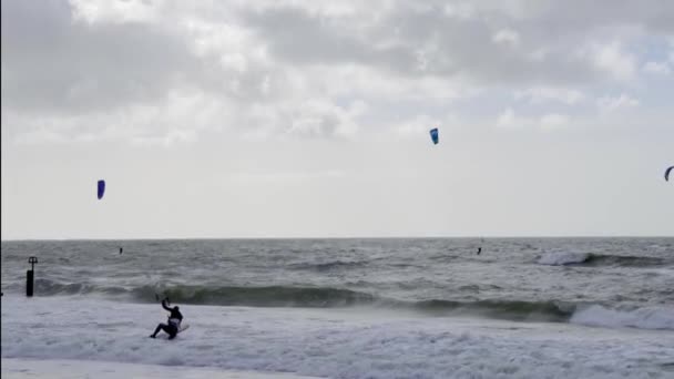 多塞特郡索斯本海滩刮风的日子里在汹涌的海面上放风筝 — 图库视频影像