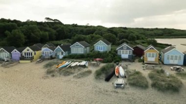 Mudeford, Dorset 'teki sahil kulübelerinin etrafında dönen İHA' nın 4K videosu.