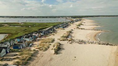 Mudeford, Dorset 'teki plaj kulübelerinin panoramik hava görüntülerini gösteren 4k drone görüntüleri.