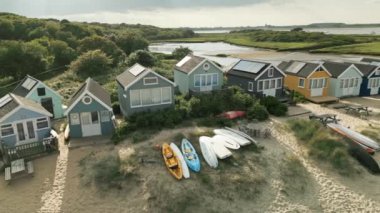 Mudeford, Dorset 'teki plaj kulübelerinin panoramik hava görüntülerini gösteren 4k drone görüntüleri.