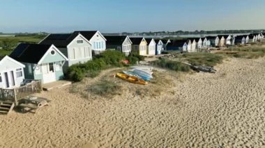 Mudeford, Dorset 'teki sahil kulübelerinin etrafında dönen İHA' nın 4K videosu.