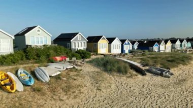 Mudeford, Dorset 'teki plaj kulübelerinin panoramik hava görüntülerini gösteren 4k drone görüntüleri.