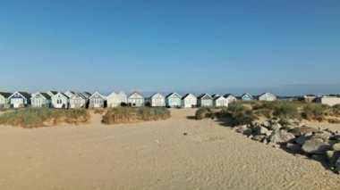 Mudeford, Dorset 'teki sahil kulübelerine doğru uçan İHA' nın 4K videosu.
