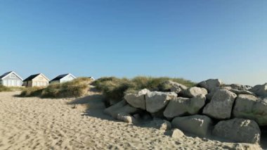 Mudeford, Dorset 'teki sahil kulübelerine doğru uçan İHA' nın 4K videosu.