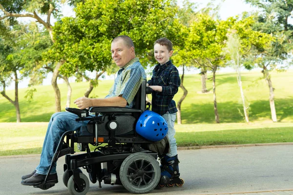 残疾父亲和儿子一起玩旱冰游戏 — 图库照片