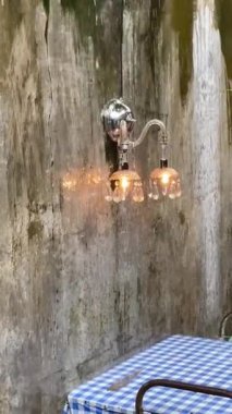 Bir kafenin içinde. Tuhaf bir yemek köşesi bulmak, kırsal cazibeyi sanatsal bir dokunuşla birleştirmek bir dinlenme anını davet ediyor. Yağmur yağdığında atmosfer böyle olur. Sandalyeler ve masalar yağmur suyu alır..