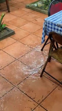 Bir kafenin içinde. Tuhaf bir yemek köşesi bulmak, kırsal cazibeyi sanatsal bir dokunuşla birleştirmek bir dinlenme anını davet ediyor. Yağmur yağdığında atmosfer böyle olur. Sandalyeler ve masalar yağmur suyu alır..