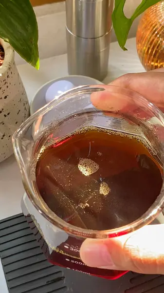 Bir tencere önünde bir bardak kahve tutan kişi, yiyecek ve içecek endüstrisi için uygun veya yemek pişirme içeriği.