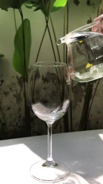 Şarap kadehini tazeleyen su. Güneşli bir günde şarap kadehine kristal berrak su dökülüyor..