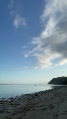 Tranquil Plajı 'ndaki Sunset' te Paddleboardcular. Sakin bir plajda canlı bir günbatımına karşı iki raket silueti.