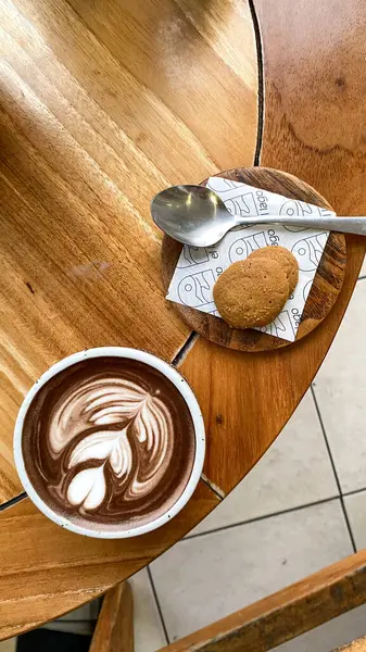 Kahve fincanı ve kurabiye masada, rahat bir kafe ya da kafe konsepti için mükemmel. Sıcak, davetkar ve lezzetli bir görüntü..
