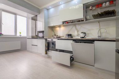Interior of well designed modern trendy white kitchen, drawers retracted